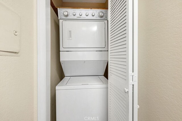 2599 Walnut Ave, Unit Signal Hill, CA 90755 - laundry room featuring stacked washer and clothes dryer and a textured wall