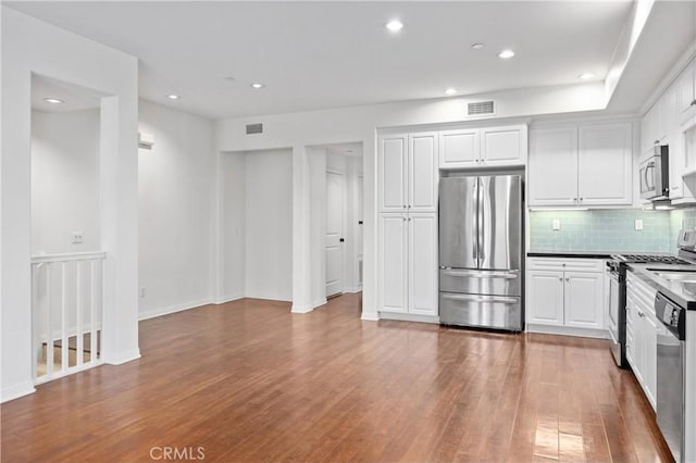 3240 S Westmont Ln Unit 5, Ontario, CA 91761 - kitchen featuring appliances with stainless steel finishes, wood finished floors, tasteful backsplash, white cabinets, and recessed lighting