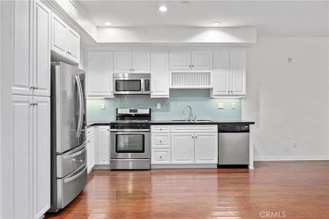 3240 S Westmont Ln Unit 5, Ontario, CA 91761 - kitchen featuring white cabinetry, a sink, dark countertops, stainless steel appliances, and baseboards