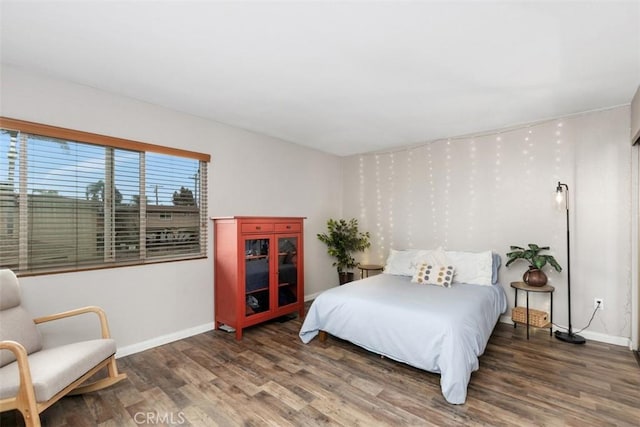 bedroom with wood finished floors and baseboards