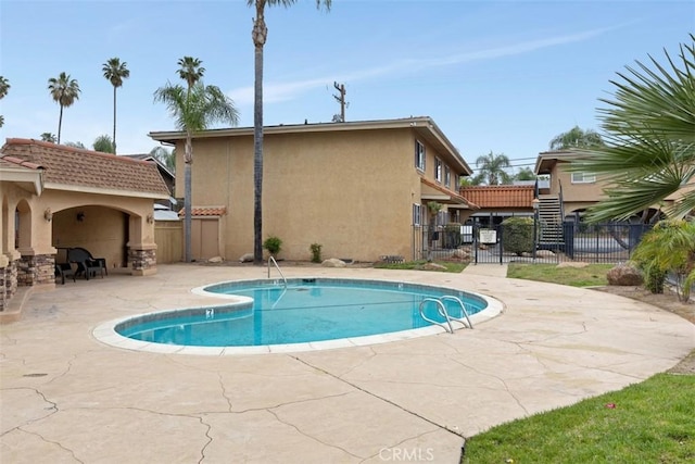 view of swimming pool with a gate, fence, a patio area, and a fenced in pool
