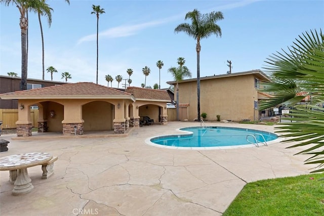 pool featuring fence and a patio