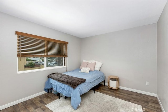 bedroom featuring baseboards and wood finished floors