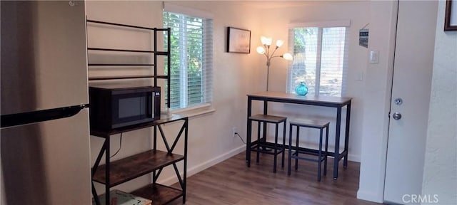 interior space featuring a wealth of natural light, wood finished floors, and baseboards