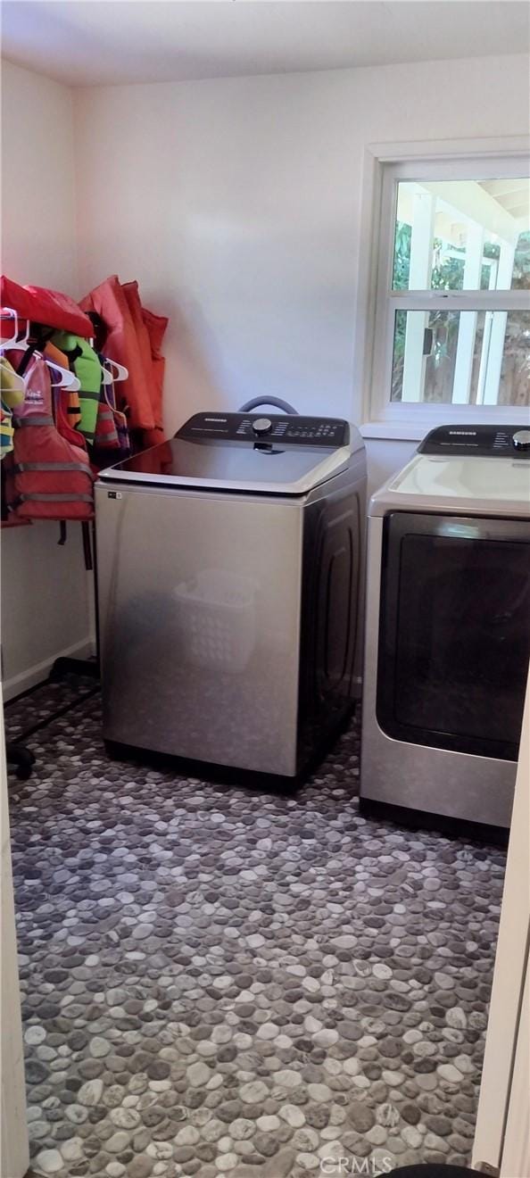 clothes washing area featuring washer and clothes dryer and laundry area
