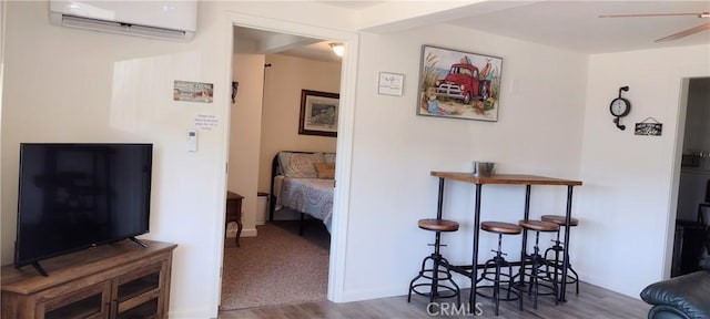 hallway featuring wood finished floors and a wall unit AC