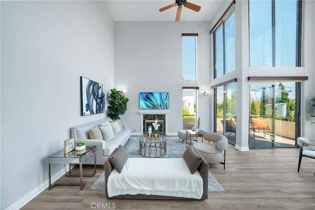 1880 Veteran Ave Unit 308, Los Angeles, CA 90025 - living room with baseboards, a towering ceiling, wood finished floors, ceiling fan, and a fireplace