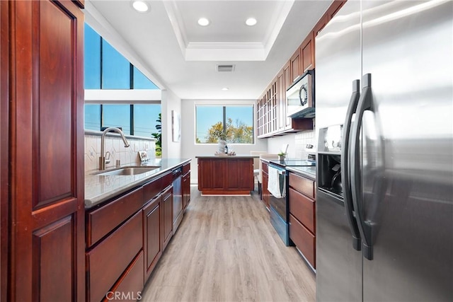 1880 Veteran Ave Unit 308, Los Angeles, CA 90025 - kitchen featuring stainless steel appliances, a raised ceiling, a sink, light wood-style floors, and a wealth of natural light