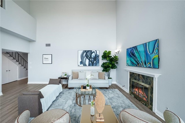 1880 Veteran Ave Unit 308, Los Angeles, CA 90025 - living room with wood finished floors, a high ceiling, a fireplace, and stairs