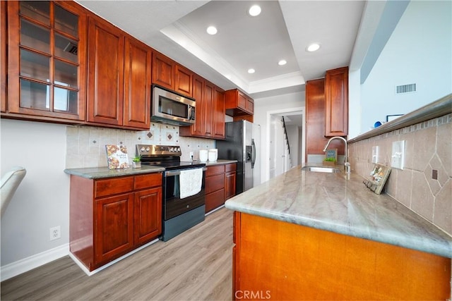 1880 Veteran Ave Unit 308, Los Angeles, CA 90025 - kitchen featuring stainless steel appliances, a tray ceiling, a sink, tasteful backsplash, and light wood-style floors