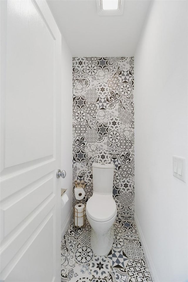 bathroom featuring toilet and baseboards