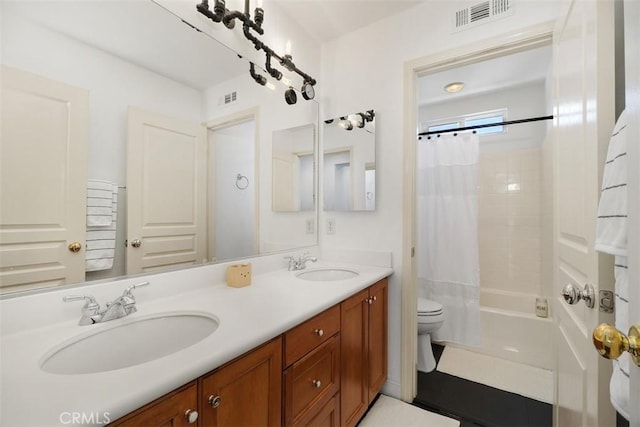 bathroom with a sink, toilet, and visible vents
