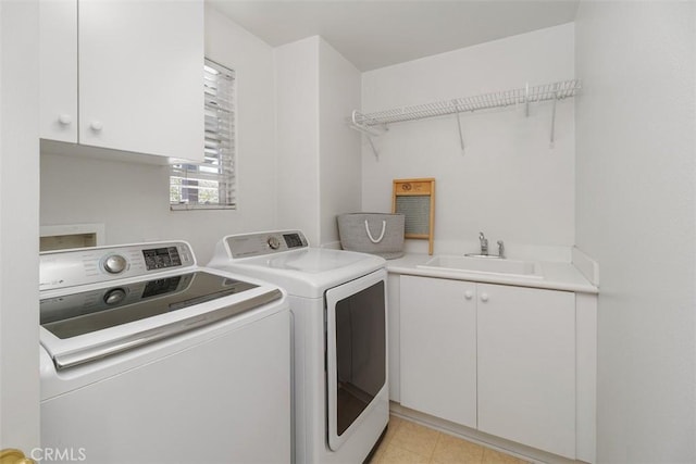 clothes washing area featuring a sink, cabinet space, and washer and clothes dryer