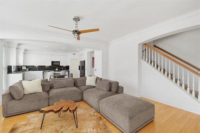 living area with ceiling fan, stairs, recessed lighting, light wood-type flooring, and ornamental molding