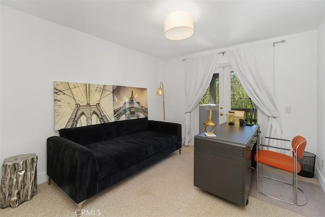 office area featuring baseboards and light colored carpet