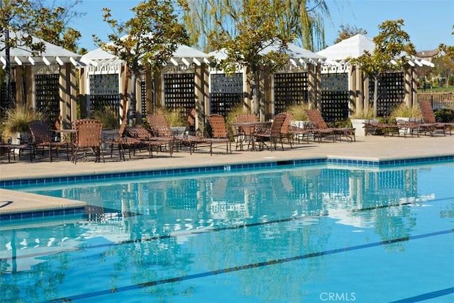 pool with fence and a pergola