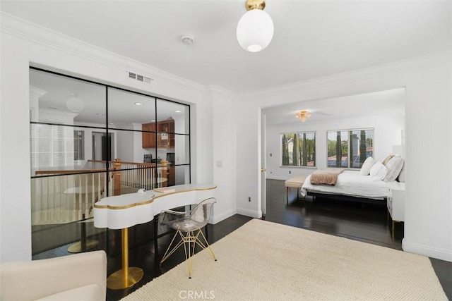 bedroom featuring dark wood-style floors, baseboards, visible vents, and ornamental molding