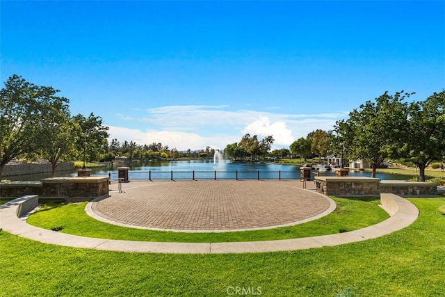 surrounding community with a water view and a yard
