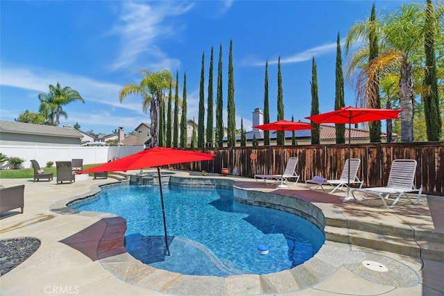 view of pool with a patio, a fenced backyard, and a pool with connected hot tub