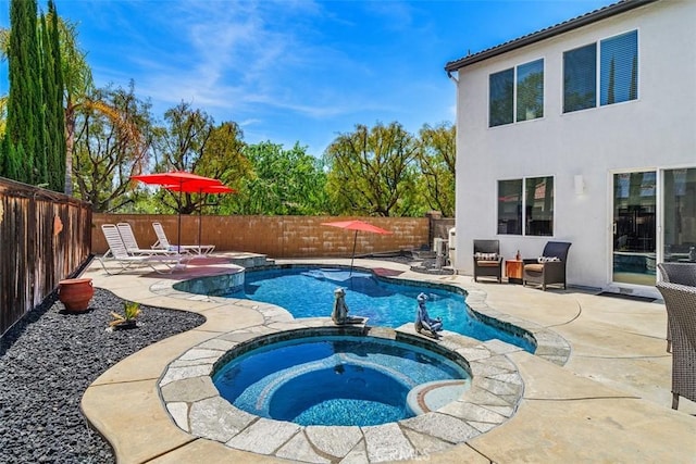 view of swimming pool with a patio, a fenced backyard, and a pool with connected hot tub