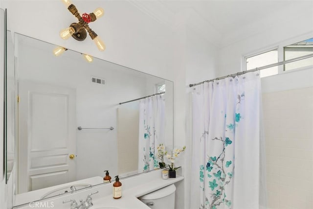 full bath with visible vents, a sink, a shower with shower curtain, and toilet