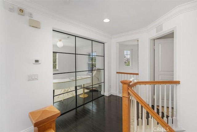 hallway with crown molding, baseboards, an upstairs landing, wood finished floors, and visible vents
