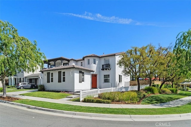 view of front facade with fence, stucco siding, and a tile roof