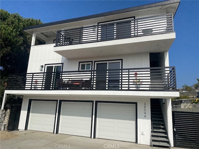 view of front of property featuring driveway, a balcony, and a garage