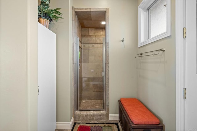 bathroom featuring baseboards and a stall shower