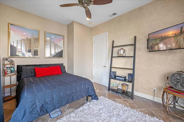 bedroom featuring stone finish floor, visible vents, baseboards, and ceiling fan