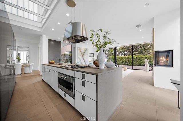 9 Temple Ave, Long Beach, CA 90803 - kitchen featuring light tile patterned floors, modern cabinets, wall oven, stainless steel gas cooktop, and white cabinetry