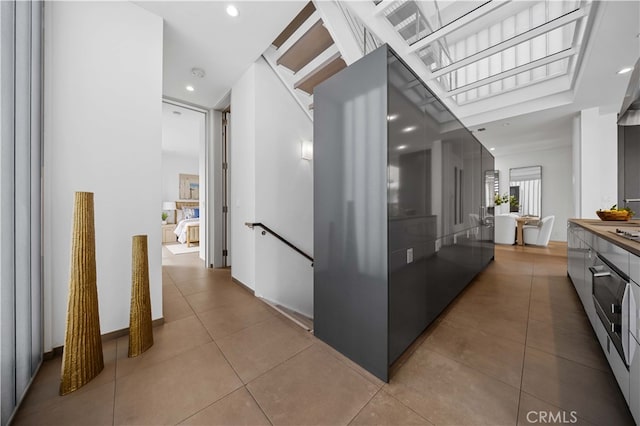 9 Temple Ave, Long Beach, CA 90803 - corridor featuring recessed lighting, tile patterned floors, and an upstairs landing