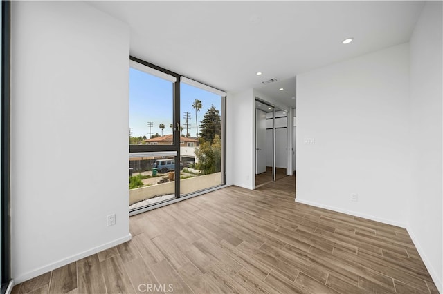 9 Temple Ave, Long Beach, CA 90803 - empty room featuring expansive windows, baseboards, wood finished floors, and visible vents