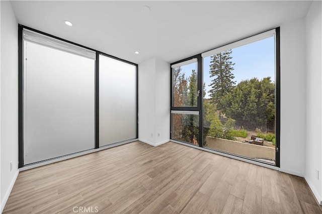 9 Temple Ave, Long Beach, CA 90803 - unfurnished room with recessed lighting, baseboards, wood finished floors, and a wall of windows