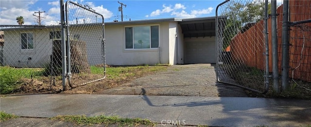view of front of property with fence, stucco siding, and aphalt driveway
