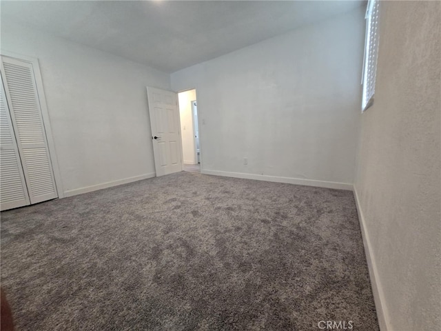 spare room featuring carpet floors and baseboards