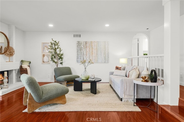 living room featuring recessed lighting, wood finished floors, visible vents, and a fireplace