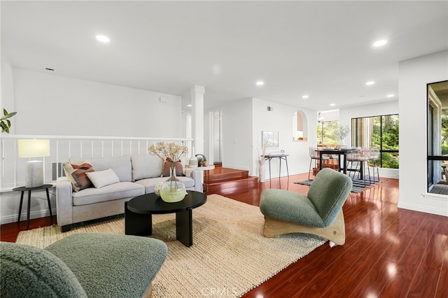 living room with baseboards, recessed lighting, wood finished floors, and decorative columns