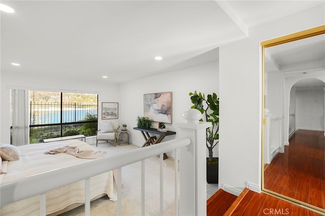 corridor featuring recessed lighting, arched walkways, wood finished floors, and baseboards