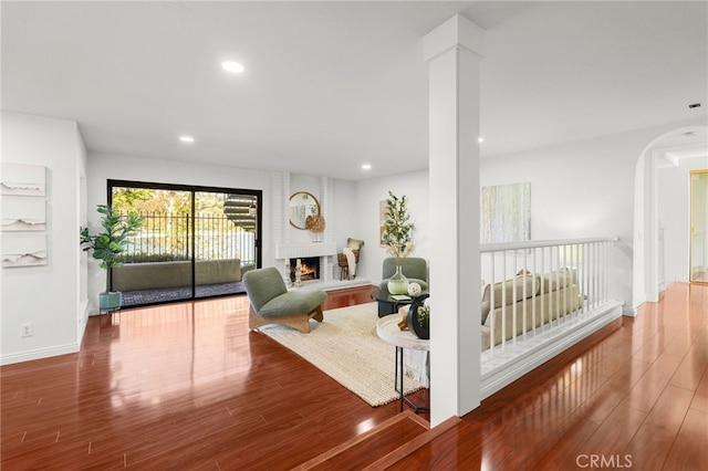 living room featuring recessed lighting, wood finished floors, and a fireplace