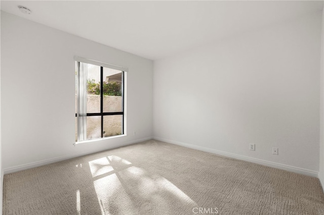 spare room featuring baseboards and carpet