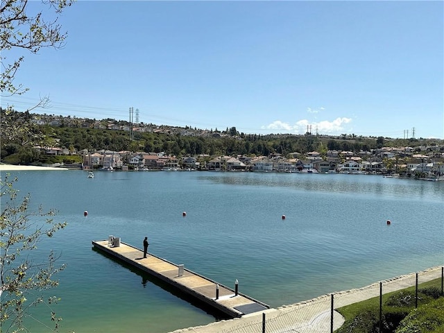 view of dock with fence and a water view