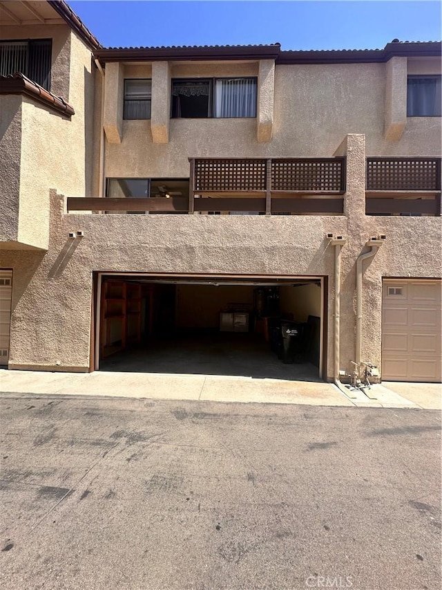 7 Wilderness Pl, Pomona, CA 91766 - rear view of property with stucco siding, a garage, and a tiled roof