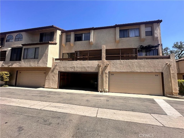 7 Wilderness Pl, Pomona, CA 91766 - townhome / multi-family property featuring an attached garage, stucco siding, and a tiled roof
