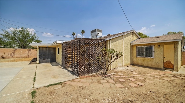 view of property exterior featuring fence, stucco siding, and a patio