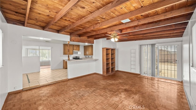 unfurnished living room with wood ceiling, beamed ceiling, a ceiling fan, and baseboards