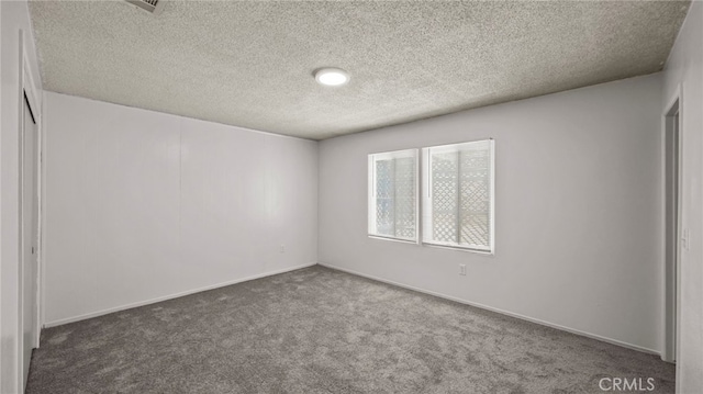 spare room featuring carpet flooring and a textured ceiling