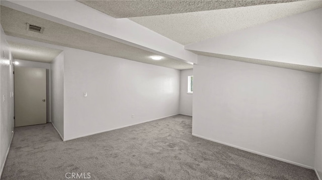 below grade area featuring carpet, a textured ceiling, and baseboards