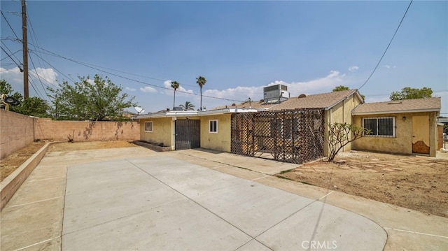 rear view of property featuring a fenced backyard, stucco siding, and a patio