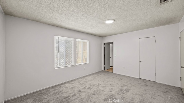 unfurnished bedroom with carpet, a textured ceiling, baseboards, and a closet